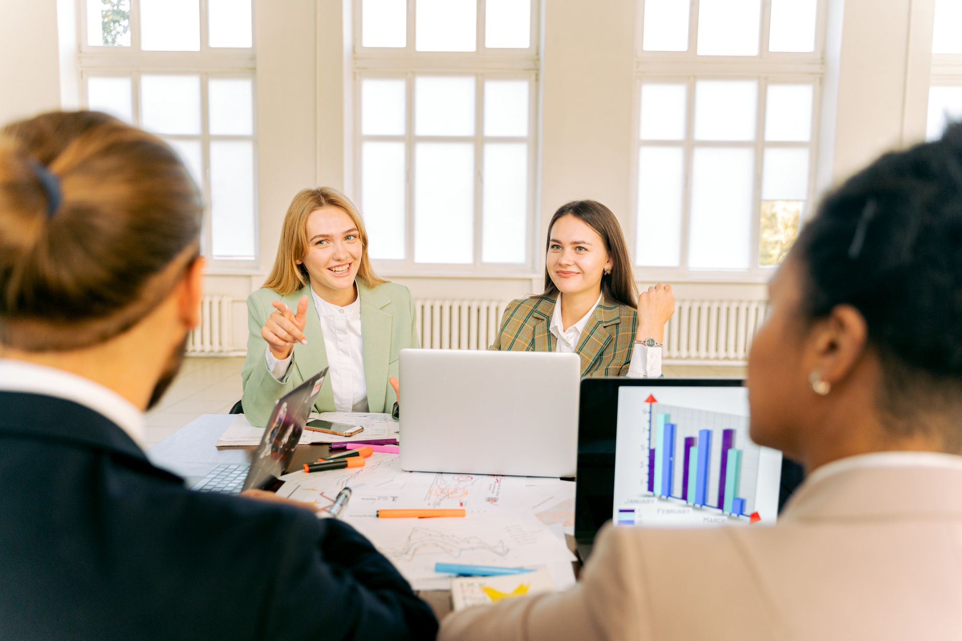 Colleagues discussing a project plan in a bright meeting room